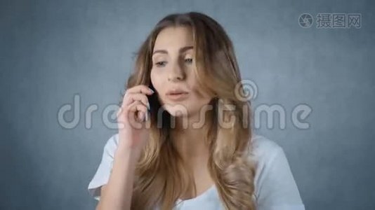 心烦意乱的女人在电话上交谈，孤立的灰色背景。视频
