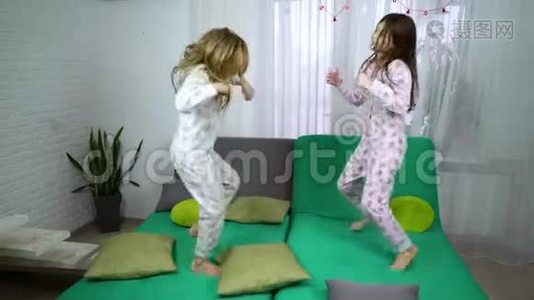 两个穿睡衣的可爱女孩在沙发上跳舞视频