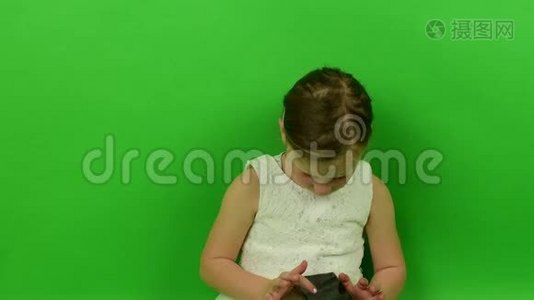 可爱的小女孩在色度键背景上使用手机。 穿着浪漫裙子的小女孩。 白色婚纱礼服视频