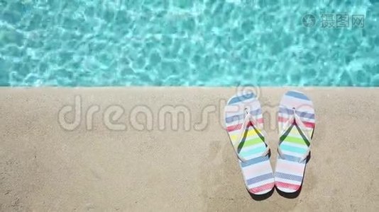 蓝色游泳池附近的彩色夏季凉鞋视频