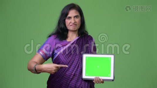 成熟美丽的印度女人展示数字平板电脑和手指视频