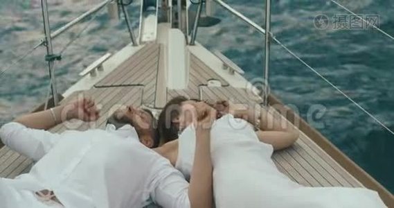 恋爱中的情侣在游艇上放松。 穿着白色衣服的男人和女人彼此拥抱，彼此温柔地享受着旅行视频