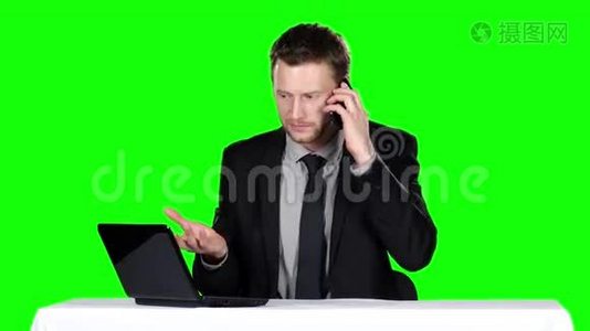商人坐着打电话。 绿色屏幕视频