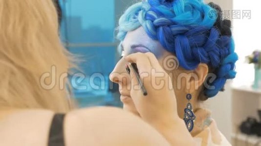 一位专业的化妆师在模特的眼皮上作画。视频