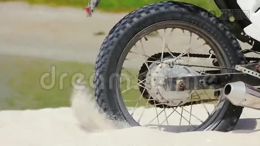 摩托车越野车车轮开始旋转，踢起地面和沙子视频