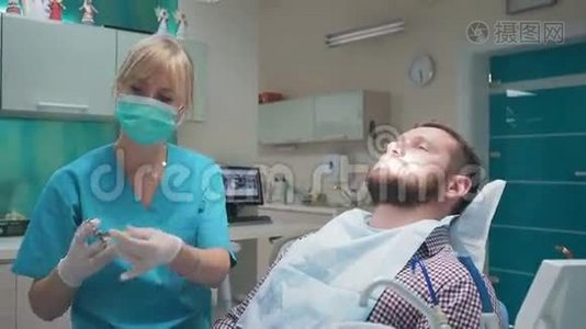 牙医在牙龈里注射麻醉剂，然后看着摄像机。视频