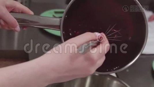 糕点厨师用搅拌器将红色浆果炖成金属锅视频