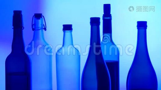 玻璃、瓶子和酒精在发光背景上的图像。视频