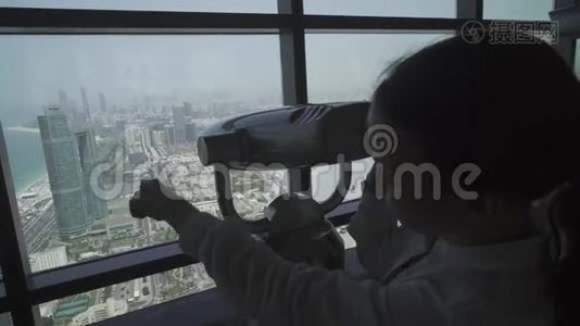 少女透过阿布扎比望远镜从观察甲板上看股票录像视频