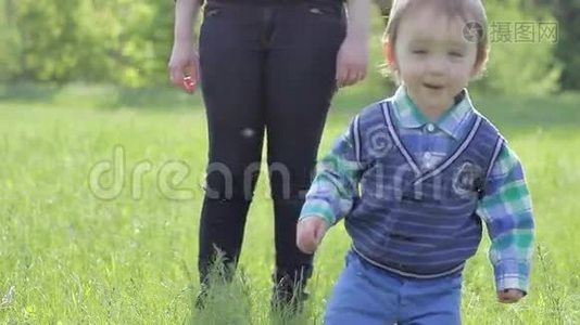 母亲带着孩子走在绿草上视频