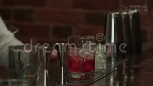 在酒吧里工作的专业酒保，把冰和酒混合在玻璃里喝视频