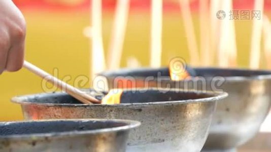 人们从一碗活火中点燃有香味的幸运魔杖和蜡烛。 佛教。视频