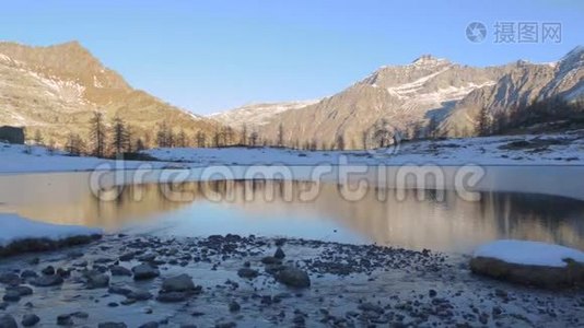 冬季河流流向意大利阿尔卑斯山冻结的山湖视频