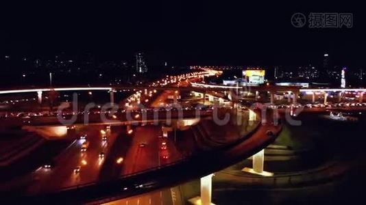 4K. 高速公路立交的鸟瞰图，夜间繁忙的城市交通在道路上超速行驶。 连接网络视频
