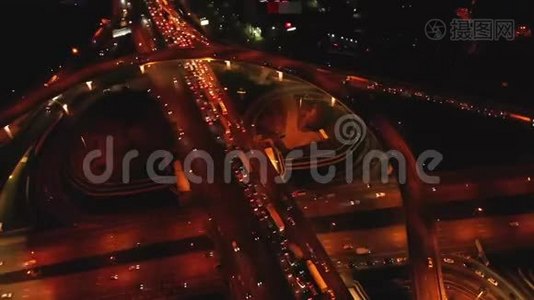 4K. 高速公路立交的鸟瞰图，夜间繁忙的城市交通在道路上超速行驶。 连接网络视频