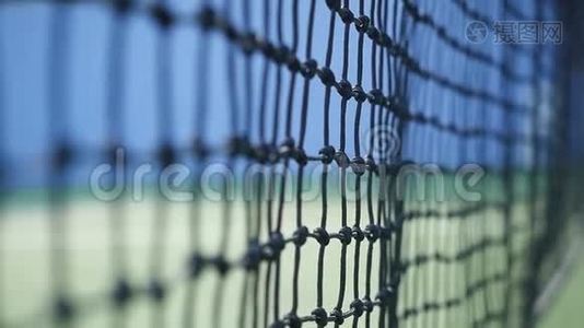 在阳光明媚的日子里，网球以缓慢的运动击中了落在网球场上的球网。 特写视频