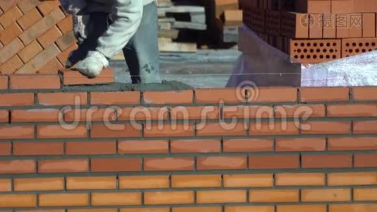 工人砌一堵砖墙. 建筑物上的建筑工人进行砌砖。 建筑工地的建筑工人视频