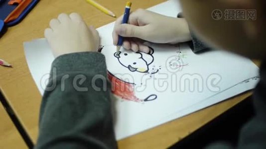 教室课桌上用彩色铅笔画男孩的高角度视图。 剪辑。 一个可爱的小男孩在画视频