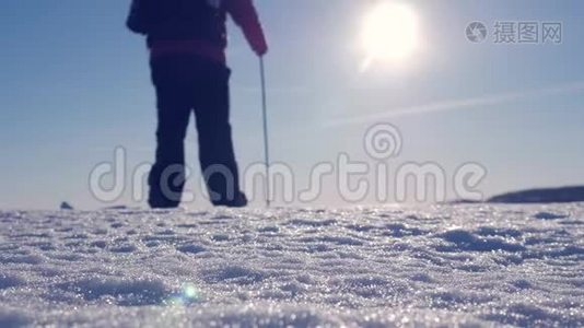 穿着雪鞋在冬天的风景中行走的人的剪影。 带着徒步旅行杆，蓝天和视频