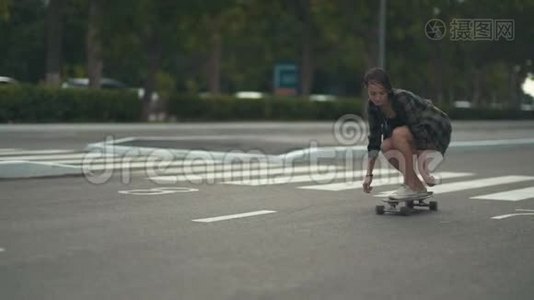 年轻漂亮的女时髦女郎白天骑滑板或长板在街上视频