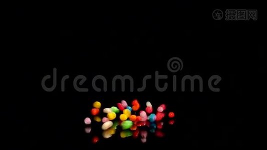 五颜六色的糖果掉落在黑桌上视频
