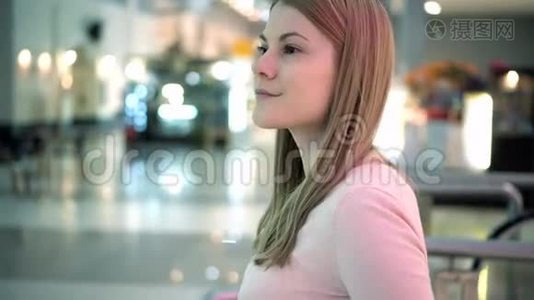 美丽迷人的年轻女子在商场等朋友。 购物消费主义概念..视频