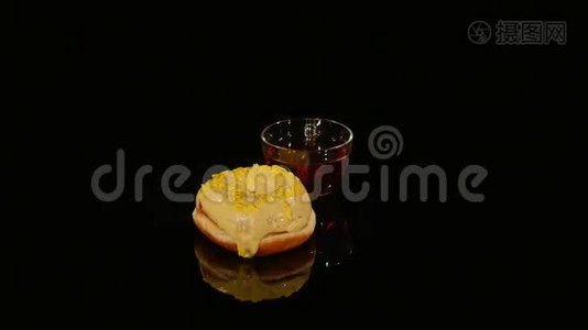 杯茶和黄釉甜甜圈在黑色背景上旋转视频