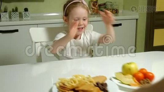 美丽的甜美女孩拒绝一盘水果、巧克力、薯片、一盘零食、巧克力、薯片视频