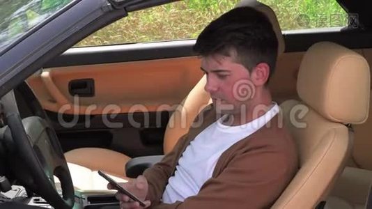 一个年轻人坐在破车里打电话视频