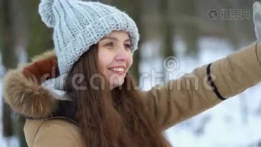 在白雪皑皑的树林里，一个年轻漂亮的女孩带着礼物，她微笑着展示礼物视频