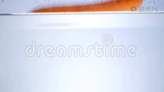 水里的胡萝卜溅在白色的背景上视频