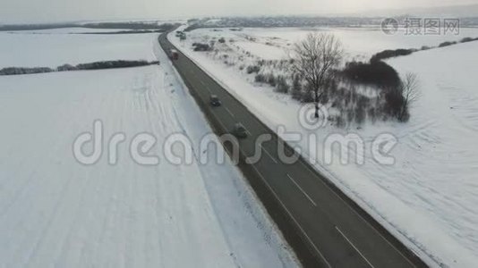 在雪域驾驶冬季道路的卡车和汽车的空中射击。视频