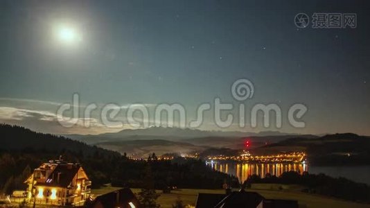 夜晚随着月亮、星星、云彩、山脉和湖泊附近的村庄而消逝视频