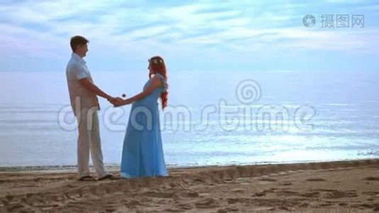 日出时两个人在海边牵手。 怀孕夫妇海滩视频