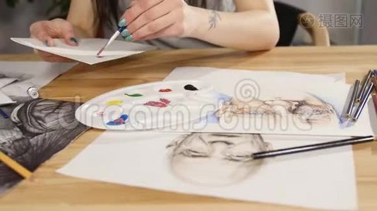 妇女手中的画笔特写，将颜料混合在调色板上视频