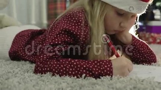 戴着圣诞帽的小女孩在写信。视频