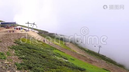 艾布拉岭。 缆车和小木屋穿过云层。 克拉斯纳亚罗萨·库特滑雪场附近的山脉视频