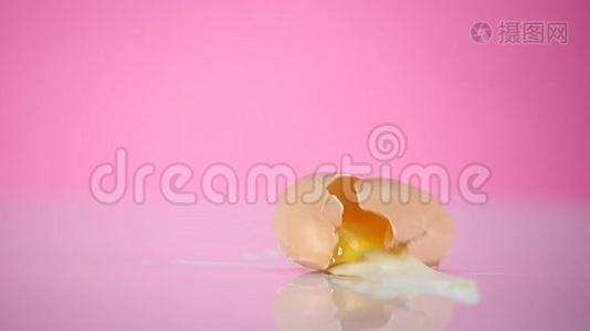 鸡蛋掉下来摔在粉红色的背景上视频