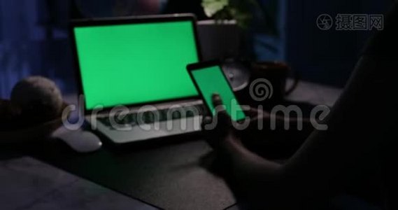 手动使用智能手机和带有绿色屏幕的笔记本电脑。 多利在视频