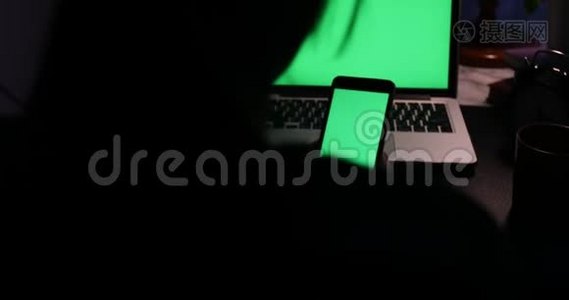 手动使用智能手机和带有绿色屏幕的笔记本电脑。 多利在视频