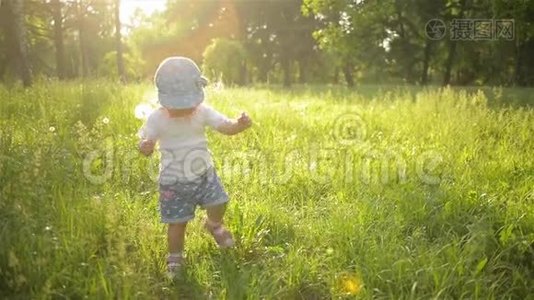 可爱的女婴走在美丽的夏日花园里，温暖的晴天视频