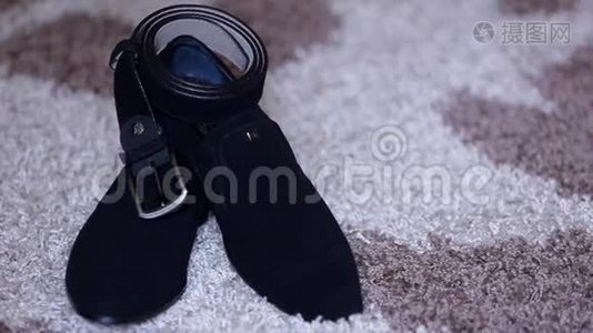 经典的黑色皮鞋和一条带扣在复古背景上的皮带视频