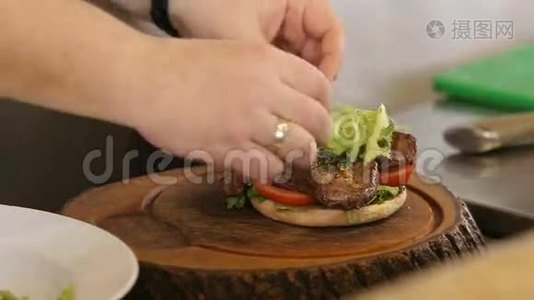 厨师把绿生菜叶放在汉堡肉上视频