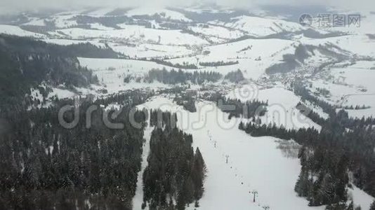 飞越喀尔巴阡山的滑雪场。 鸟瞰群山中白雪覆盖的房屋..视频