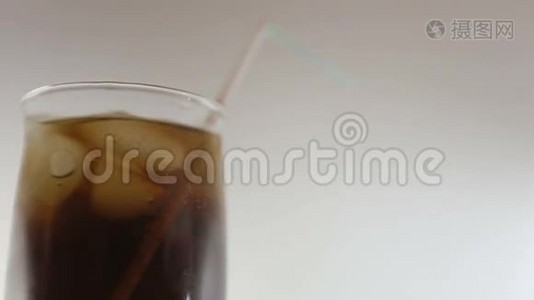 杯子里有冰块的可乐和吸管视频