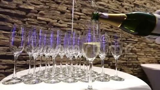 服务员把香槟倒入玻璃杯中，香槟杯放在自助餐桌上，餐厅或酒店的大厅，视频