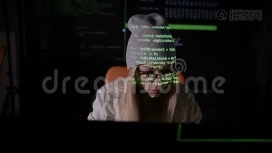女性黑客在黑暗中在电脑里工作。 她脸上的二进制代码投影。 打滑头。 前景。视频