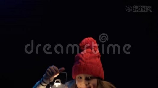小女孩戴着针织冬帽围巾提着灯笼散步视频