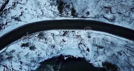 空中无人驾驶飞机观看蜿蜒曲折的公路穿过山林视频