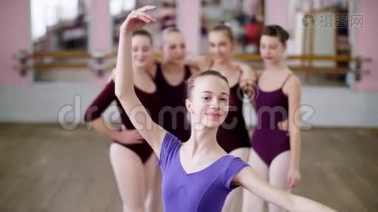 一位年轻的女孩芭蕾舞演员穿着淡紫色芭蕾舞紧身衣的肖像，微笑着，优雅地表演着芭蕾舞的身影。视频